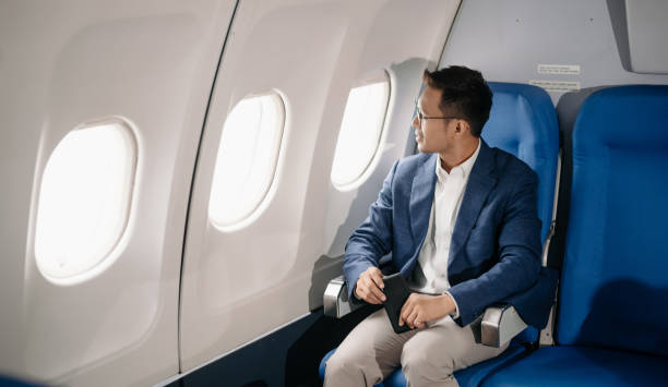 istock Young Asian executive excels in first class, multitasking with digital tablet, laptop and smartphone. Travel in style, 2159315209