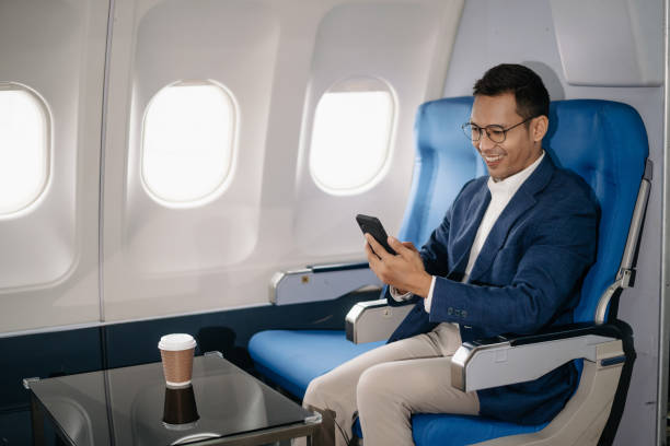 istock Young Asian executive excels in first class, multitasking with digital tablet, laptop and smartphone. Travel in style, 2159315222