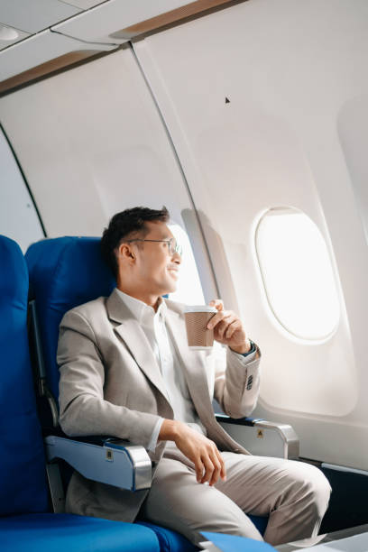 istock Young Asian executive excels in first class, multitasking with digital tablet, laptop and smartphone. Travel in style, 2159315255