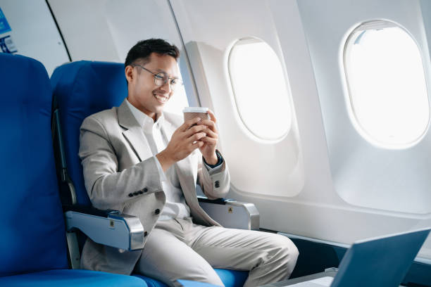 istock Young Asian executive excels in first class, multitasking with digital tablet, laptop and smartphone. Travel in style, 2159315264