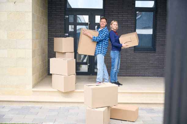 istock Man and woman standing back to back and holding boxes 2159315559