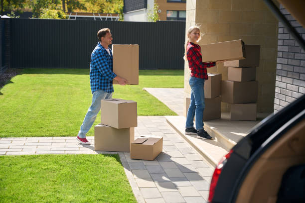 istock Cheerful couple carrying and arranging boxes on house doorstep 2159315573