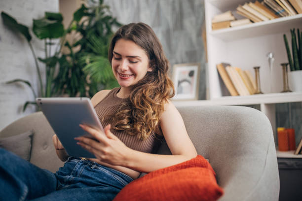 istock Woman with tablet and relaxed pose on couch 2159321133