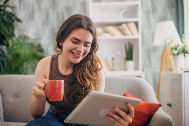 istock Cheerful woman with tablet and red mug 2159321193