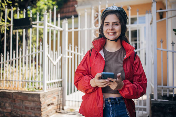 istock Delivery woman with phone and backpack smiling 2159323595