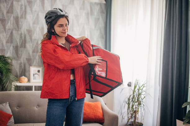 istock Delivery worker with helmet holding large red bag 2159324289