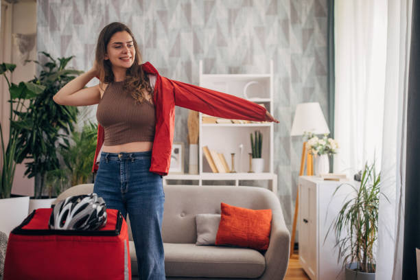 istock Woman putting on a red jacket preparing to leave 2159324421