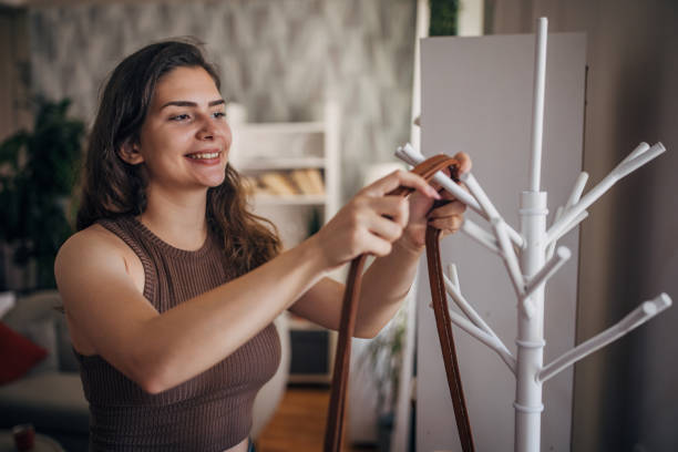 istock Young woman arranging coat stand at home 2159325567
