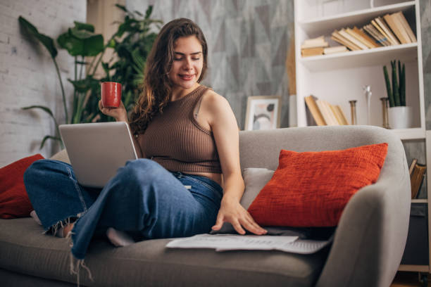 istock Smiling woman with laptop and a mug 2159328110