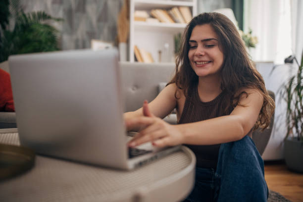istock Young woman using laptop at home 2159328548