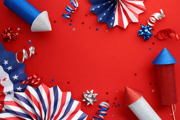 istock Patriotic decorations on a red background for USA national holidays. Flat lay composition with paper fans, fireworks rockets, party streamers. Happy 4th of July Independence day banner template 2159329961