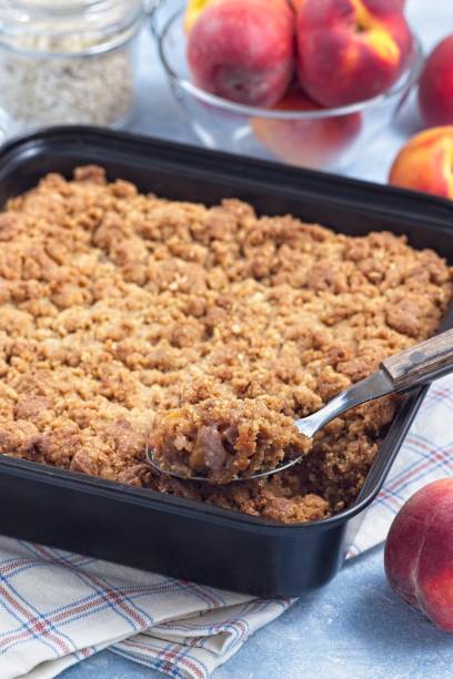 istock Peach Crisp or cobbler with brown sugar and oat streusel in backing dish, vertical 2159332456