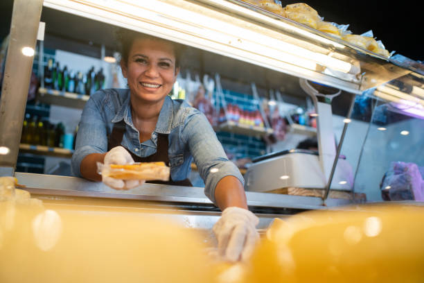 istock Happy woman arranging the cheese refrigerator display at a delicatessen 2159332631
