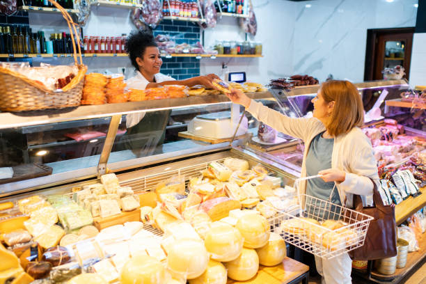 istock Shopkeeper serving a woman customer in a delicatessen 2159332665
