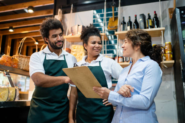 istock Grocery store manager reviewing inventory with workers in delicatessen 2159332700