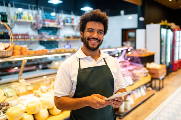 istock Smiling grocery shop salesman with digital tablet managing inventory 2159332707