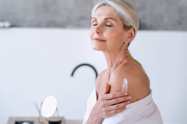 istock Mature woman applying hydration lotion on shoulder and body 2159333270