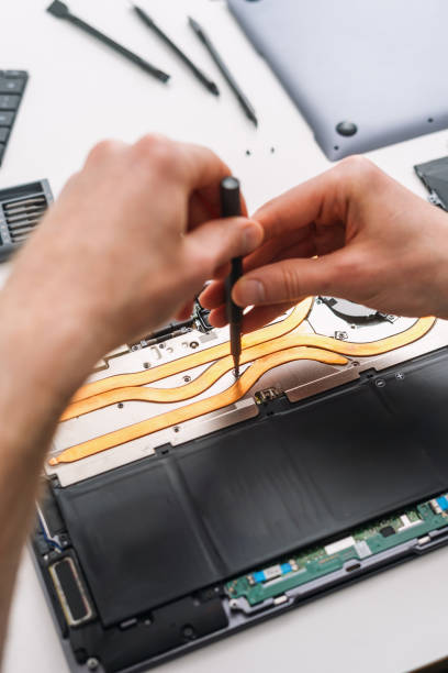 istock Man repairing his laptop, removing old battery 2159333358