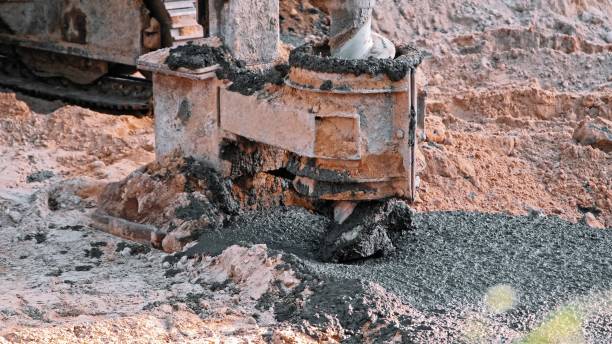 istock Construction Site Pale Driver Equipment Drill Covered in Fresh Concrete Cement during Foundation Laying Works 2159333557
