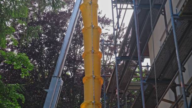 istock External Modular Plastic Trash Chute Attached to Scaffolding at Construction Site During Roof Renovation 2159333593