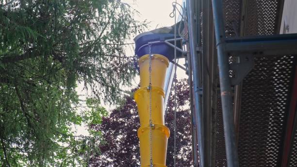istock External Modular Plastic Trash Chute Attached to Scaffolding at Construction Site During Roof Renovation 2159333595