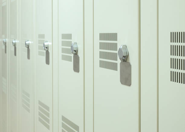 A portrait of an elementary age boy carrying his backpack and standing by his locker smiling.