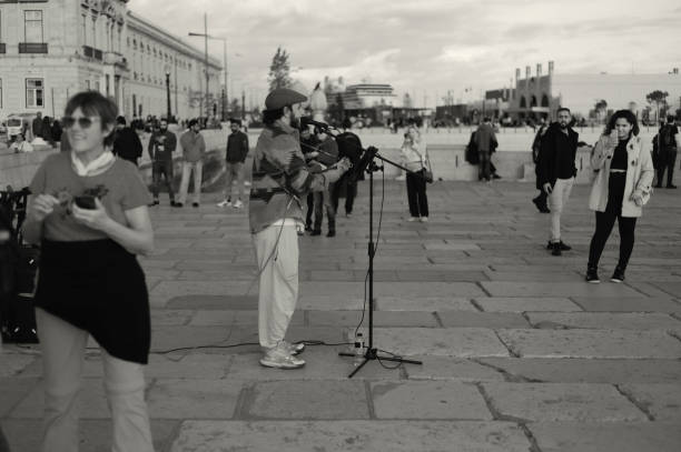 Lisbon, Portugal - November 11, 2023: A street musician plays a ukulele by the Tagus River in Lisbon downtown.