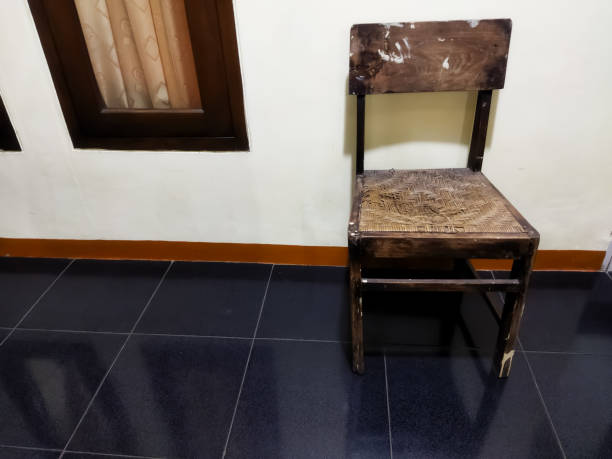 Wooden chair with a blue striped pillow stands on the street