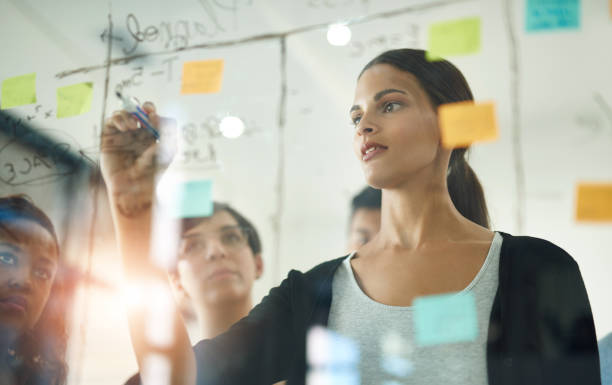 istock Glass, planning and writing with business people in office together for coaching or training. Meeting, storyboard and workshop with employee team in workplace with sticky note for upskill development 2159343155