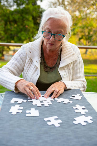 istock Old Woman doing jigsaw puzzle in garden 2159344982