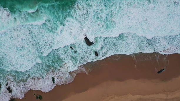 istock Turquoise surf splashing coast making foam aerial view. Ocean waves patterns 2159346227