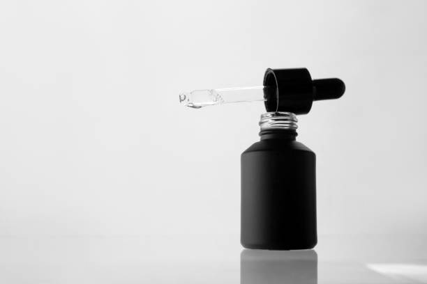 istock Cosmetic pipette with oil on a light background, reflected from the surface 2159347160
