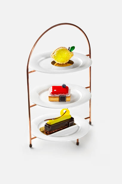 istock Three tier dessert stand with lemon shaped cake, small cheesecake with berry jelly and chocolate cake with banana mousse 2159349179
