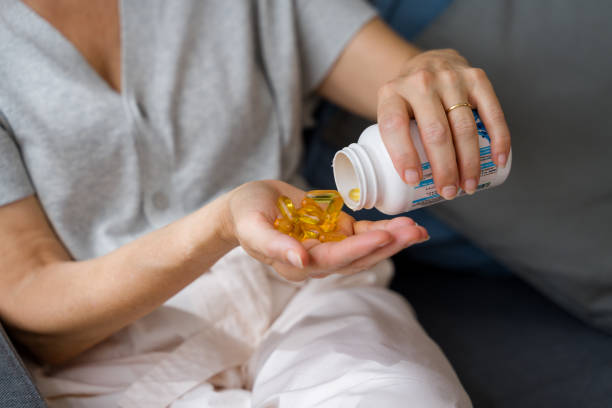 Woman taking vitamins or pills for treatment at home