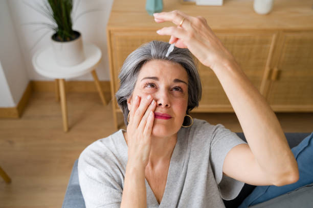 istock Senior woman applying eye drops at home 2159351196