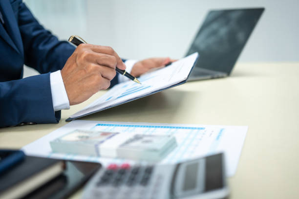 istock A banker in a suit works at a desk handling loans, analyzing client financial data, providing financial advice, dealing with stocks and the stock market, and studying economic situations. 2159351564