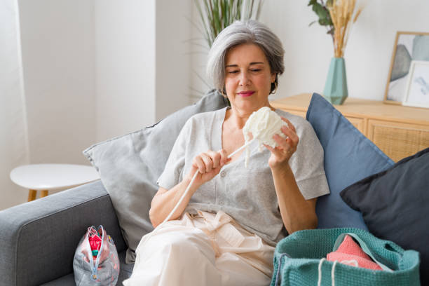 istock Senior woman choosing wool yarn relaxing on sofa at home 2159351877