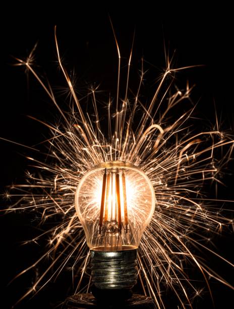 istock Close-up of a light bulb with sparkling fireworks in the background 2159353585