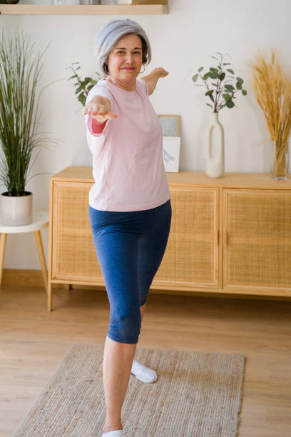 istock Senior woman practicing yoga at home for wellbeing 2159353932