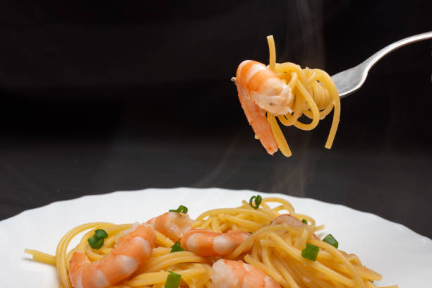 istock A plate of spaghetti with shrimp on a fork, a delicious seafood dish 2159354742