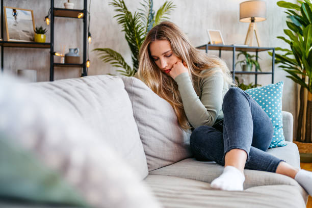 istock Sad Young Woman Sitting At Home On The Sofa 2159356554