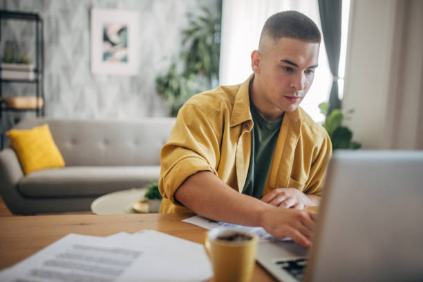 istock Man in yellow working on laptop with coffee 2159359026