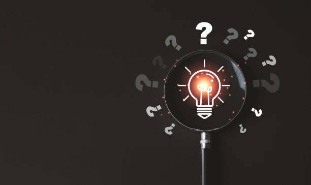 istock Glowing lightbulb inside of magnifier glass with question mark on dark background for creative thinking idea problem solving and solution concept. 2159360158