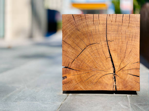A close-up view of a square wooden beam with visible wood grain and cracks