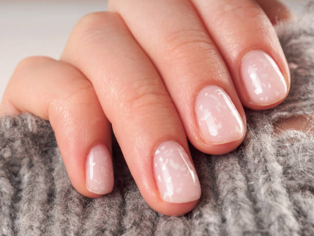 istock Women's manicure shellac soft pink color close-up 2159364433