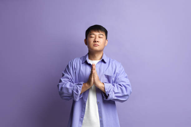 istock Peaceful Man Meditating at Studio. Portrait of Asian Guy Doing Prayer Gesture 2159365948