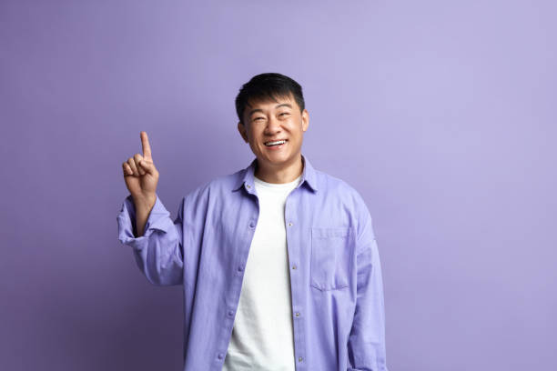 istock Smiling Man Pointing Hand. Positive Guy Pointing Away Paying Your Attention 2159365951