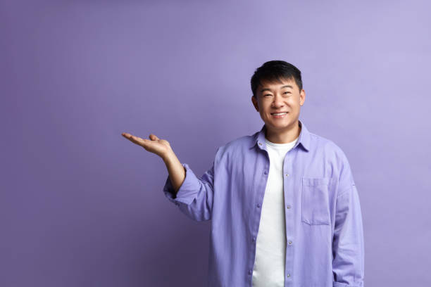 istock Smiling Man Pointing Hand. Positive Guy Pointing Away Paying Your Attention 2159365952