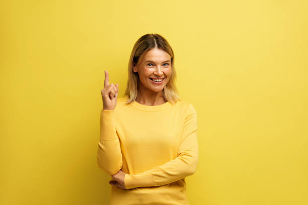 istock Cheerful Woman Pointing Up at Studio. Overjoyed Girl Points Finger Empty Space 2159366620