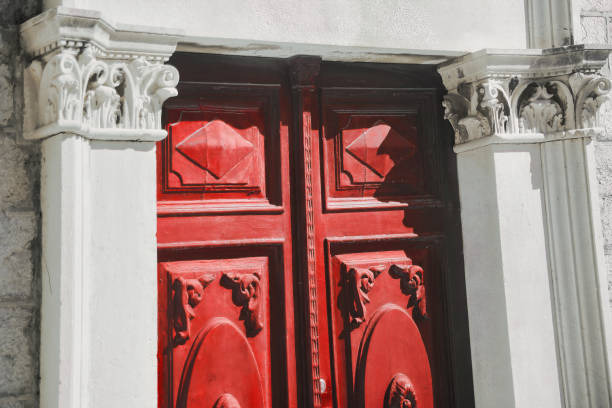 A red door with gold handles and knockers